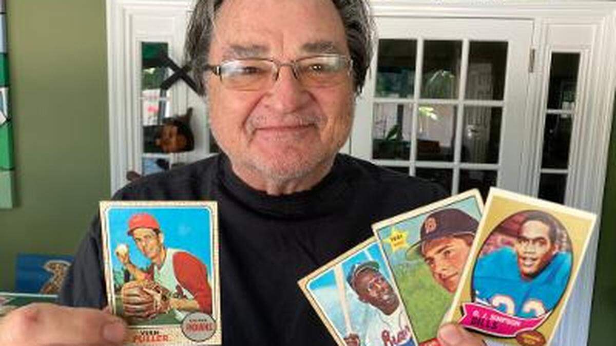 El columnista deportivo del Miami Herald Greg Cote con algunas de los varios cientos de tarjetas de béisbol y football de su infancia en los años 60 que redescubrió recientemente guardadas en cajas de zapatos dentro de contenedores en su garaje.
