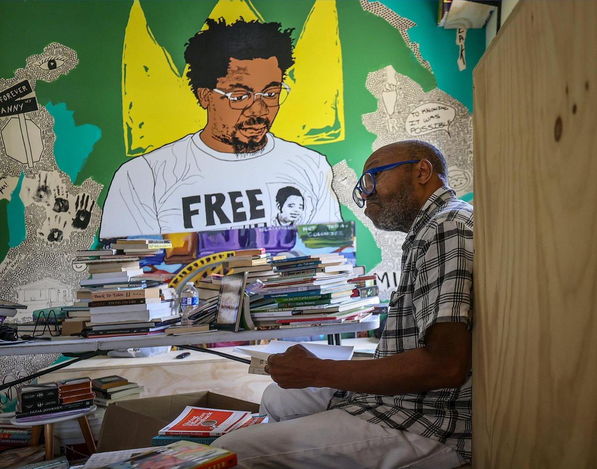 Barney Agnew, 71, the father of the late Danny Agnew, helps sort through the thousands of books at the new Roots Bookstore and Marketplace in Liberty City.  Agnew was a book seller in Chicago and donated many of the books from his own collection to the store. 