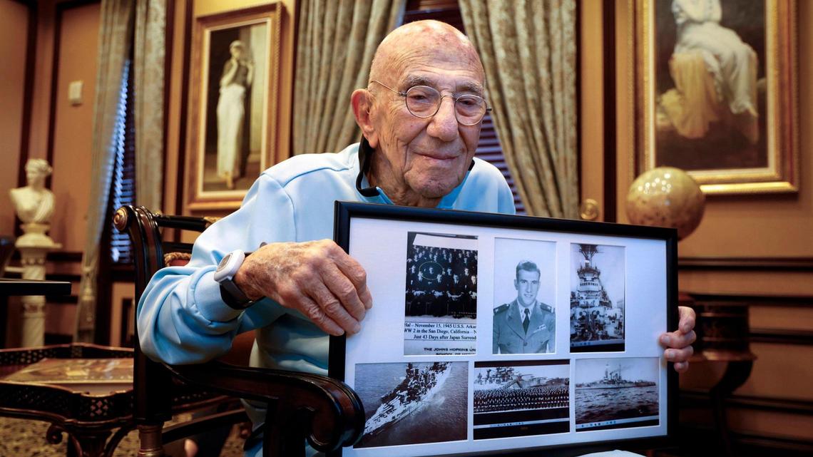 Dr. Hal Silberman, 99, a U.S. Navy veteran, on Thursday, Nov. 7, 2024, holds a series of photographs taken while he served in the military during World War II. He now lives at The Palace in Coral Gables, Florida.