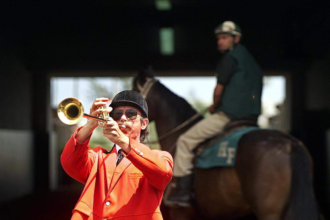 In this file photo from March 17, 1999, Stuart King plays his trumpet to announce the start of the first race at Hialeah Park. He also played at Gulfstream.