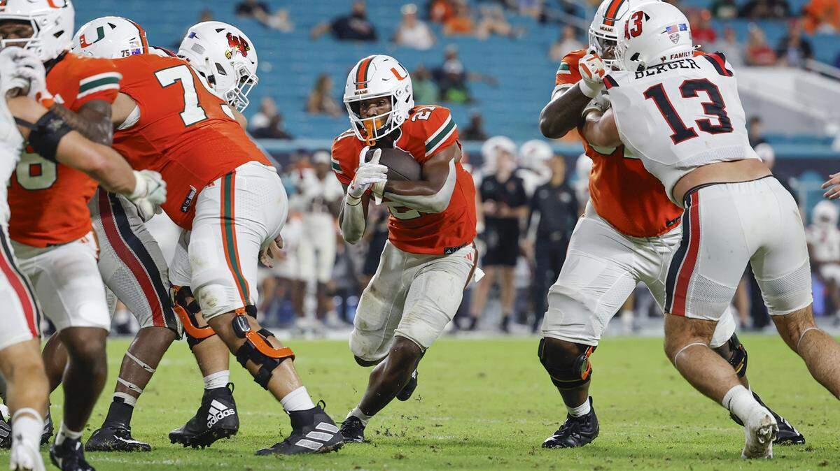 The Miami Hurricanes’ offensive line paves the way for running back Jordan Lyle (21) in the second half of an NCAA football game against the Ball State Cardinals at Hard Rock Stadium in Miami Gardens, Florida on Saturday, September 14, 2024.
