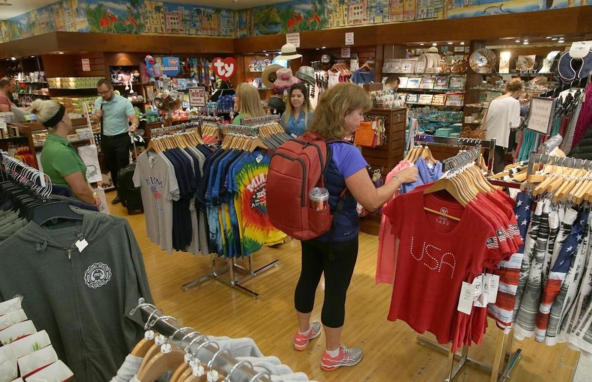 Travelers check out items at Miami To Go store owned by Carole Ann Taylor at Miami International Airport.