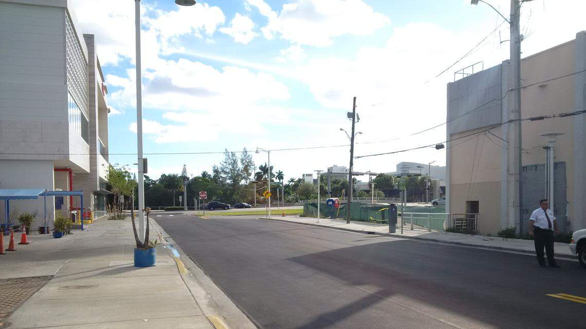 Pylons and a chain across the exit of South Beach Finest Hand Car Wash on the far left and, on the far right behind the security guard, the filled-in hole in the back of the Office Depot where Jose Antonio Reyes Bermudez crashed a Mercedes SUV after being shot.