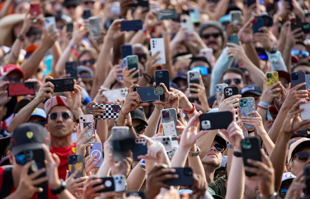 Fans use their phones as McLaren driver Lando Norris of Britain takes the podium after winning the Formula One Miami Grand Prix at the Miami International Autodrome.