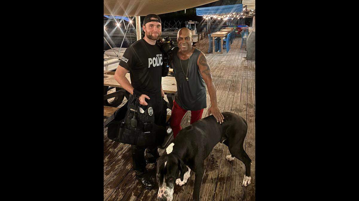 Key West Police Officer Corey Vanderhoof stands with a man and his Great Dane after rescuing them from the water on Wednesday, May 27, 2026.