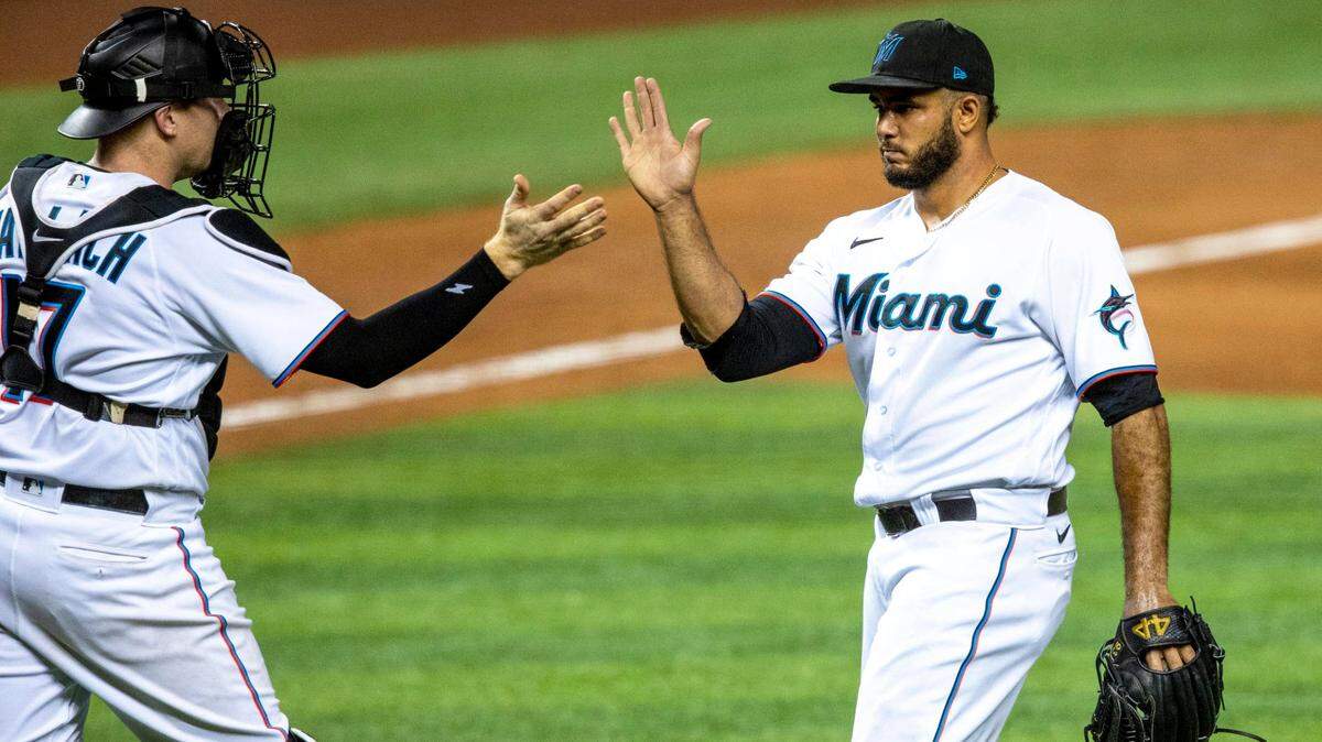Miami Marlins pitcher Yimi García (93) high-fives catcher Chad Wallach (17) after the ninth inning of an MLB game against the Arizona Diamondbacks at loanDepot park in the Little Havana neighborhood of Miami, Florida, on Thursday, May 6, 2021. The Marlins defeated the Arizona Diamondbacks 3-1 to sweep the series. 