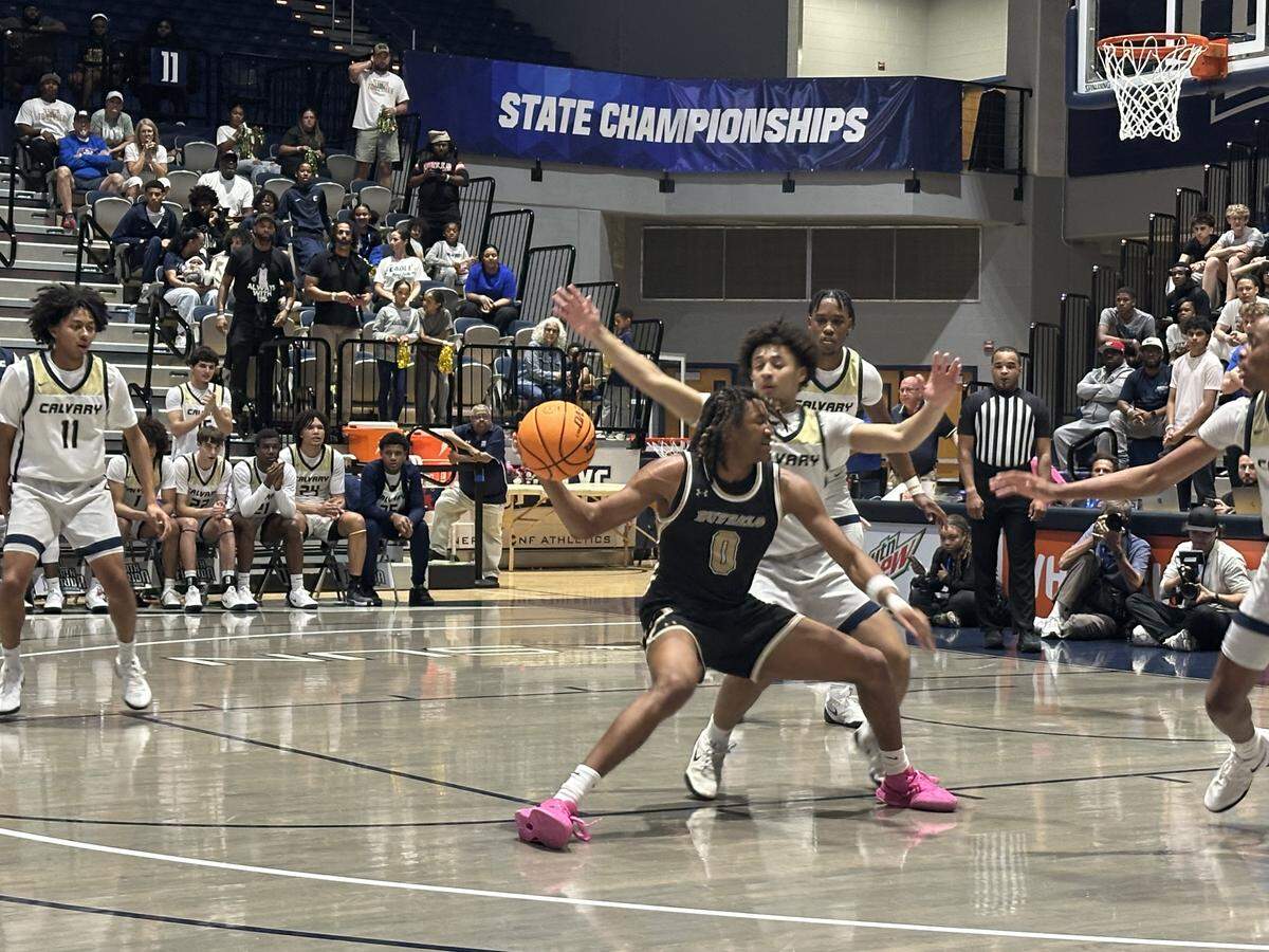 Calvary Christian’s Xavier Lebron defends The Villages’ Herly Brutus (0) during Wednesday’s Class 3A state championship game at UNF Arena in Jacksonville, Fla.
