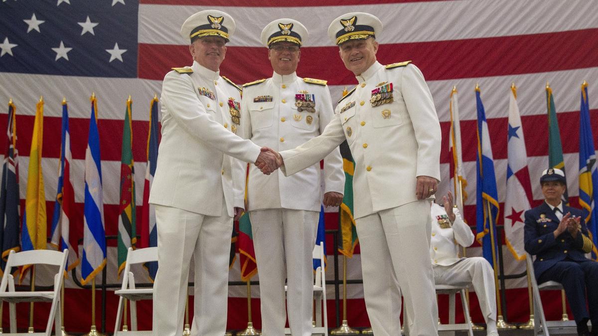 New Commander of the Coast Guard Seventh District, Rear Adm. Eric C. Jones, left, and the outgoing commander of the same district, Rear Adm. Peter J. Brown, right, shake hands as the Vice Adm. Scott A. Buschman, Commander of the Coast Guard Atlantic Area, watches at Coast Guard Air Station Miami in Opa-locka on Wednesday, June 19, 2019.