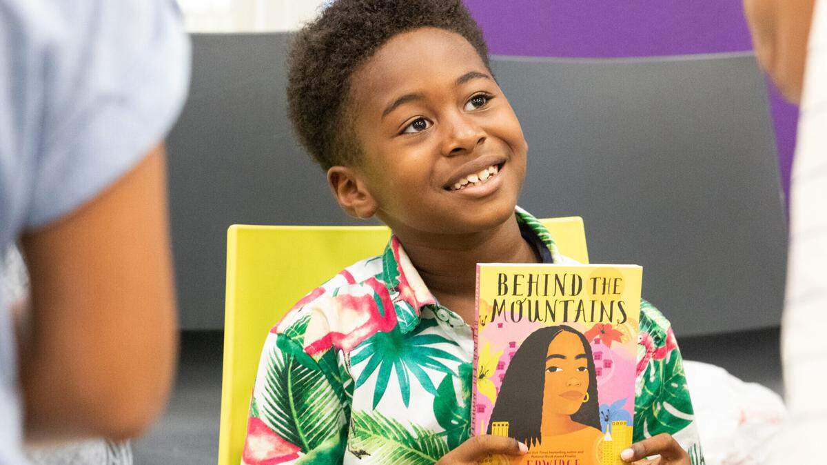 A young reader and his book during the 2022 Little Haiti Book Festival. The festival returns Sunday, May 7, at three locations in the Miami neighborhood. (Photo courtesy of Miami Book Fair).
