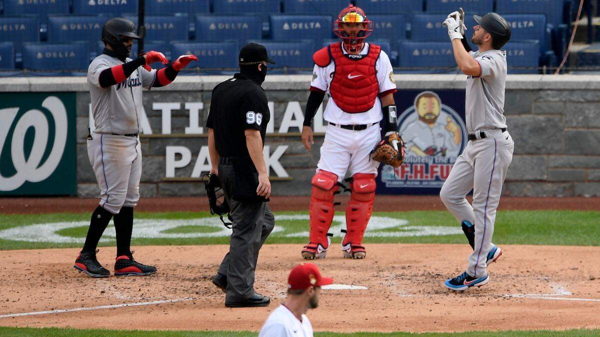 Miami Marlins’ Matt Joyce, right, celebrates his two-run home run with Jonathan Villar, left, as Washington Nationals catcher Kurt Suzuki waits during the fifth inning of the first baseball game of a doubleheader, Saturday, Aug. 22, 2020, in Washington. (AP Photo/Nick Wass)