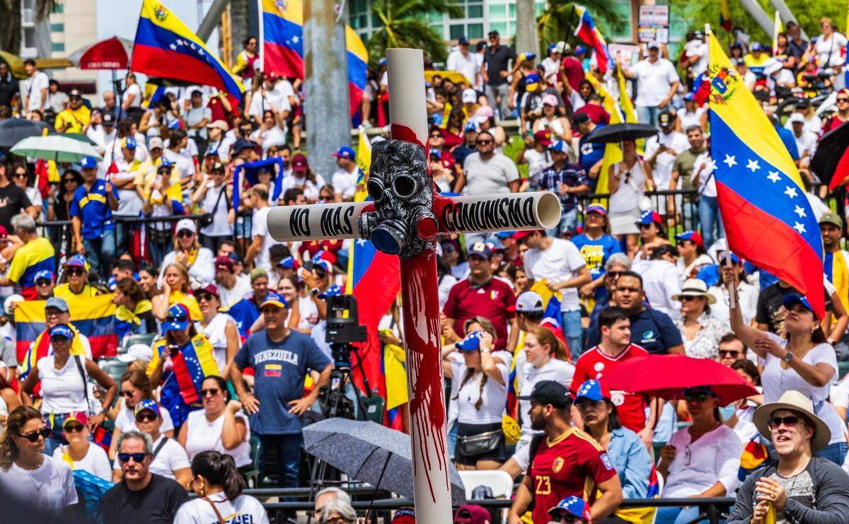 A cross made out of pvc tubes bears the words No More Communism as local Venezuelans protest in Downtown Miami.