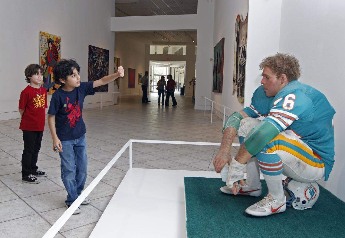 Ian Pretto, 8, right and brother Ginmarco Pretto,7, checks to see if the sculpture “Football Player” is real. The 1981 oil on polyvinyl and mixed media sculpture by artist Duane Hanson is on display in the Contemporary Hall of the Lowe Art Museum at the University of Miami on Tuesday, January 31, 2012