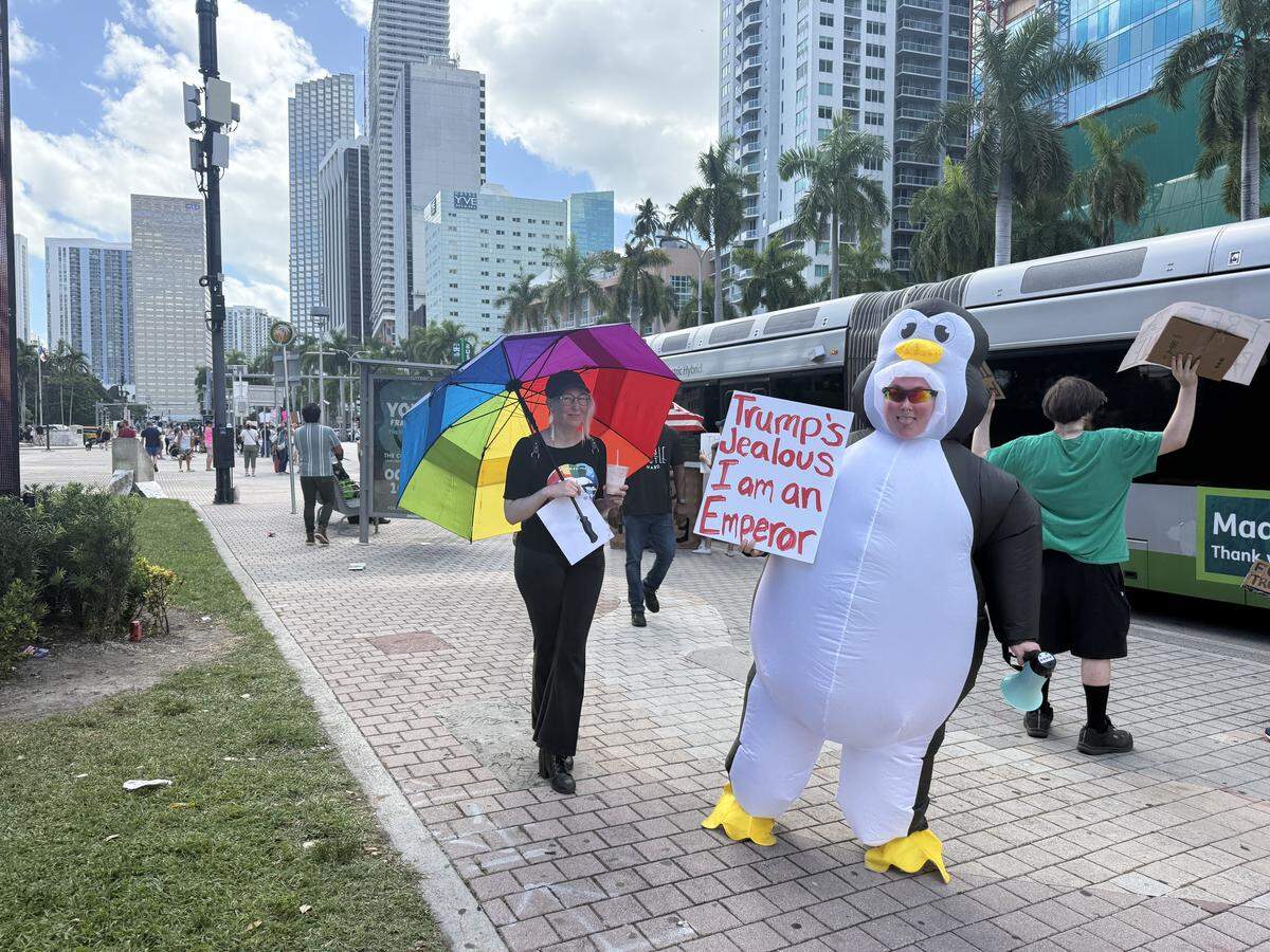 “Trump’s jealous I am an emperor,” says the sign carried by a “No Kings” protester in downtown Miami on Oct. 18.