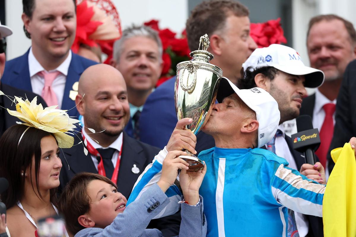 Core owner Ramiro Restrepo, left, smiles as jockey Javier Castellano celebrates in the winner’s circle after guiding Mage to victory in the 149th Kentucky Derby at Churchill Downs last Saturday.