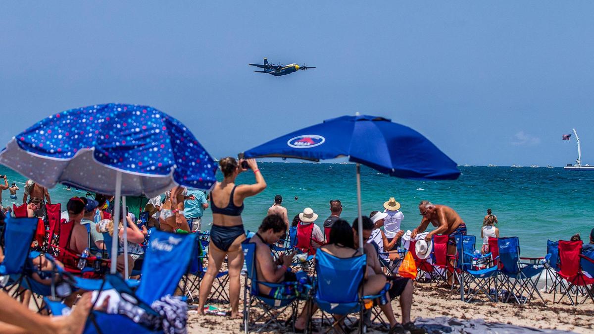 Beachgoers look up at an A C-130 Hercules with the U.S. Navy Blue Angels flying at the 2023 Fort Lauderdale Air Show on Saturday April 29, 2023.