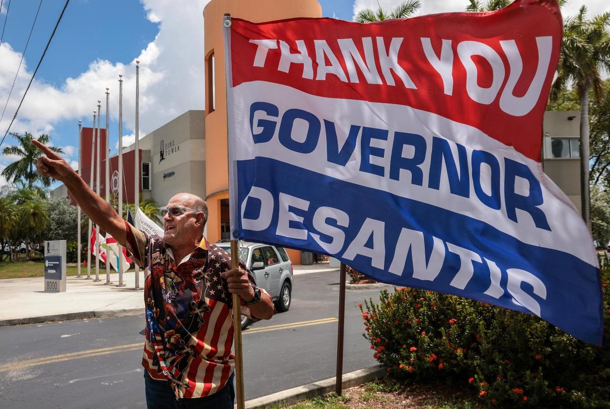 A supporter of Gov. Ron DeSantis heckles protesters on Sunday, August 21, 2022 outside Metro-Dade Firefighters Local 1403 in Doral, Florida, where DeSantis spoke at a campaign event in support of school board candidates he endorsed.