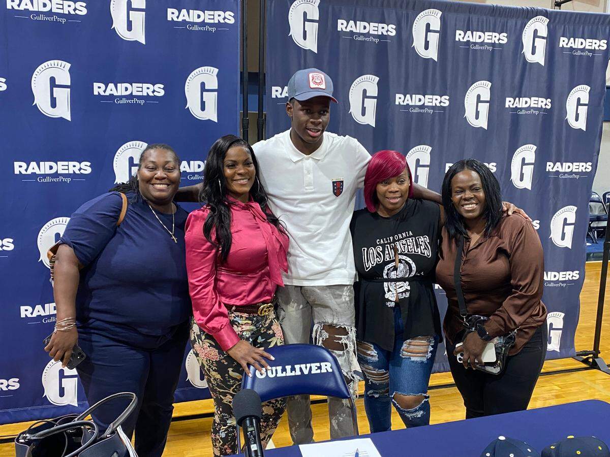 Gulliver cornerback Daniel Harris poses with family, wearing a Georgia Bulldogs cap, moments after he signed a letter of intent on Wednesday to play for the reigning national champions.