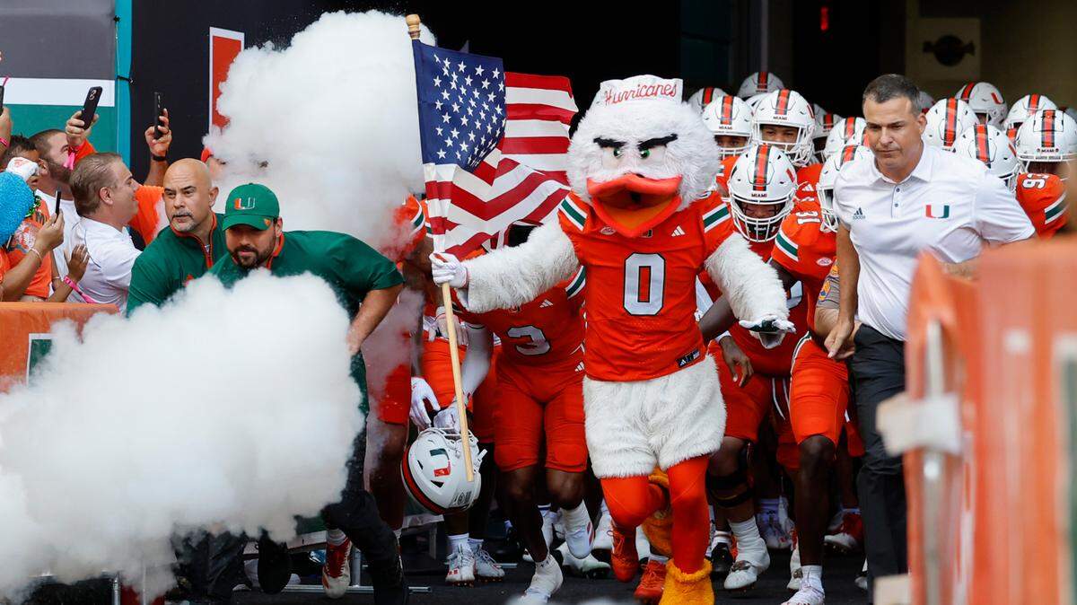 Miami Hurricanes head coach Mario Cristobal, Ibis, and players run onto the field before the start of the game against the Florida A&M Rattlers at Hard Rock Stadium in Miami Gardens, Florida, on Saturday, September 7, 2024.