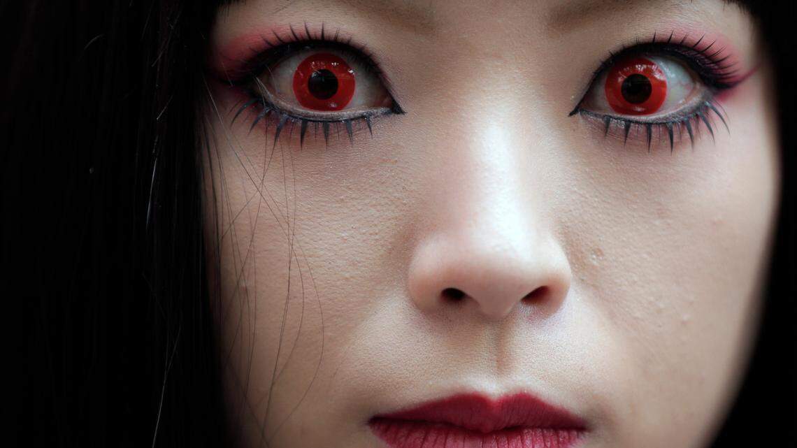 A woman puts on red contact lenses at a Halloween event in Kawasaki, near Tokyo, Sunday, Oct. 28, 2012.