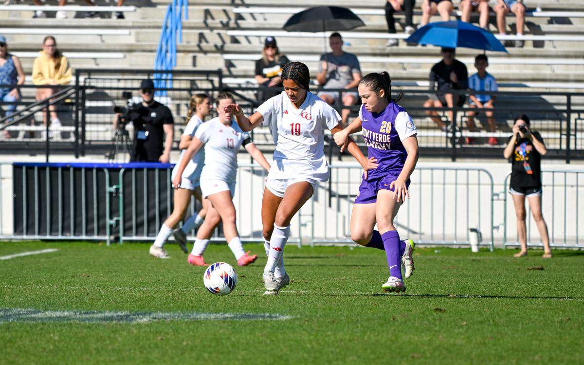 Cardinal Gibbons’ Reagan Hood (19) fights for possession against Montverde Academy’s Veronica Solano (20) during Saturday’s Class 3A girls’ soccer state championship game at Lake Myrtle Sports Complex in Auburndale, Fla.