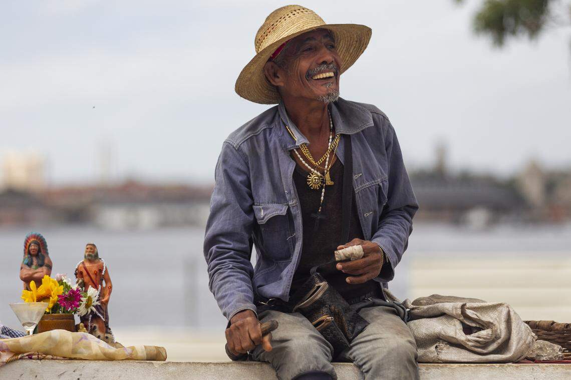 The Church of Nuestra Señora de Regla is a magnet for various religious traditions, including Santeria. This man sits near African deities outside the church.