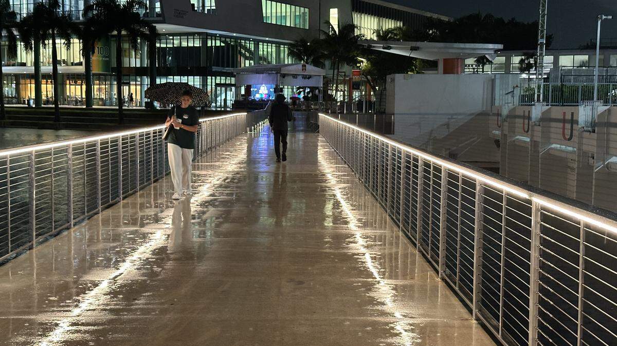 File photo: University of Miami students break out the umbrellas on the Lake Osceola bridge Thursday night, Sept. 18, 2025.
