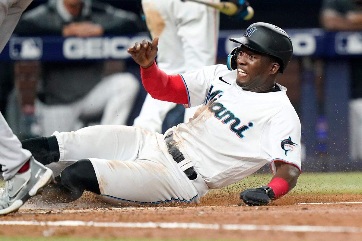 Miami Marlins’ Jesus Sanchez scores on a passed ball by St. Louis Cardinals catcher Yadier Molina during the fourth inning of a baseball game against the St. Louis Cardinals, Thursday, April 21, 2022, in Miami. (AP Photo/Lynne Sladky)