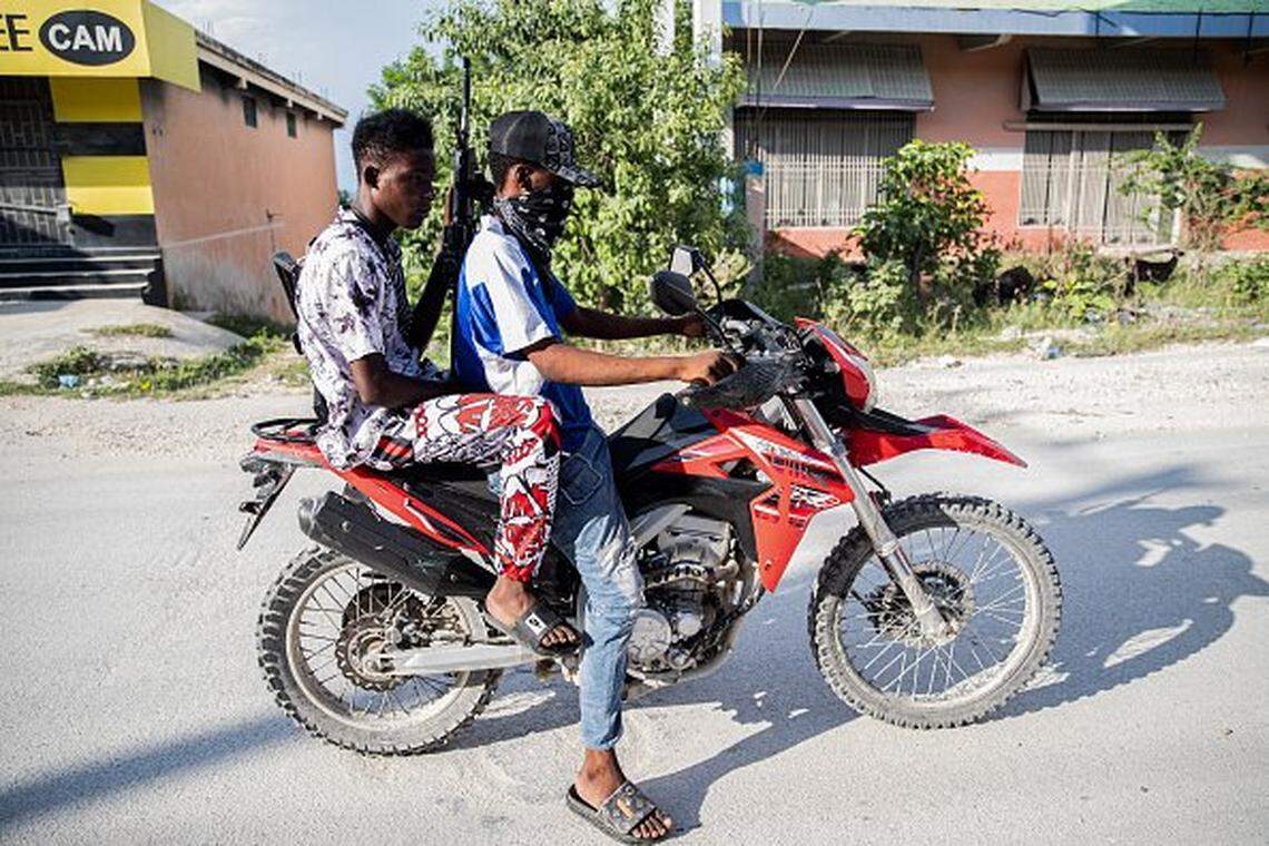 Armed gang members on a motorbike patrol the streets in the Mariani neighborhood of Port-au-Prince, Haiti, on October 6, 2025. Mariani is near the Route Nationale 2, parts of which have been taken over by gangs. More than 16,000 people have been killed in armed violence in Haiti since the start of 2022, the United Nations said on October 2, warning that "the worst may be yet to come". The poorest country in the Americas, Haiti has long suffered at the hands of violent criminal gangs that commit murders, rapes, looting, and kidnappings against a backdrop of chronic political instability. (Photo by Clarens SIFFROY / AFP) (Photo by CLARENS SIFFROY/AFP via Getty Images)
