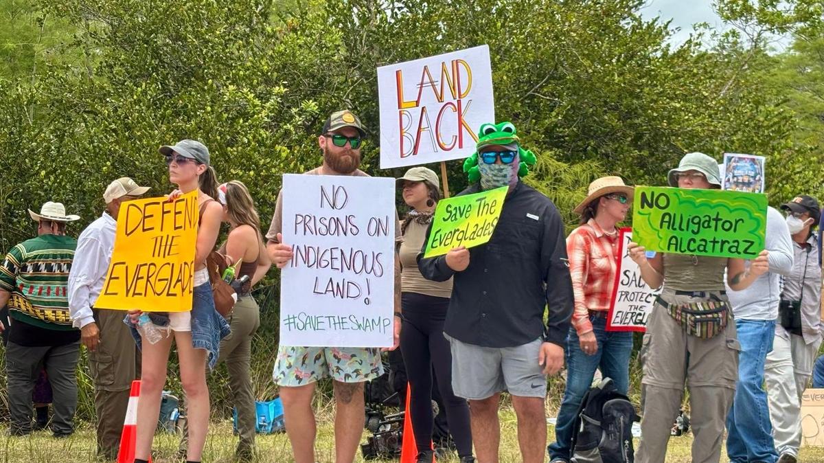 Ochopee, Florida, June 28, 2025 - Protesters outside the Dade-Collier Training and Transition Airport hold signs voicing their opposition to the construction of a massive detention facility for undocumented immigrants on the site, which is in the middle of the Florida Everglades. 