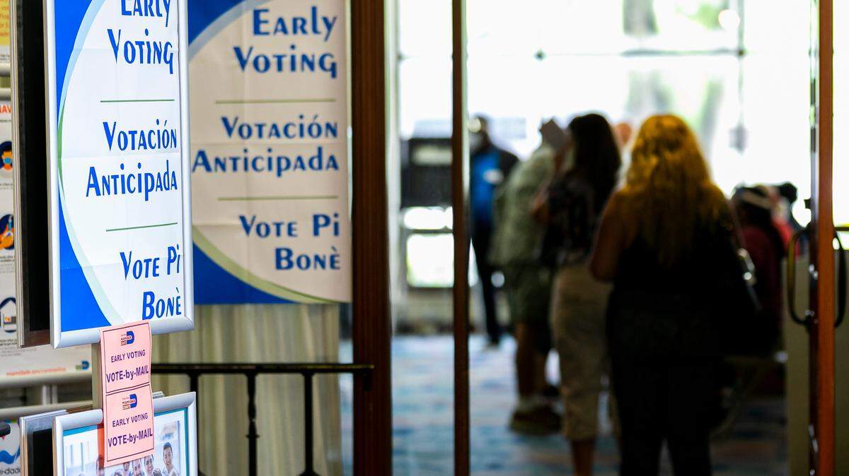 Voters make their way toward the voting booth on the first day of early voting at the Coral Gables Branch Library in Coral Gables, Florida on Monday, August 3, 2020.