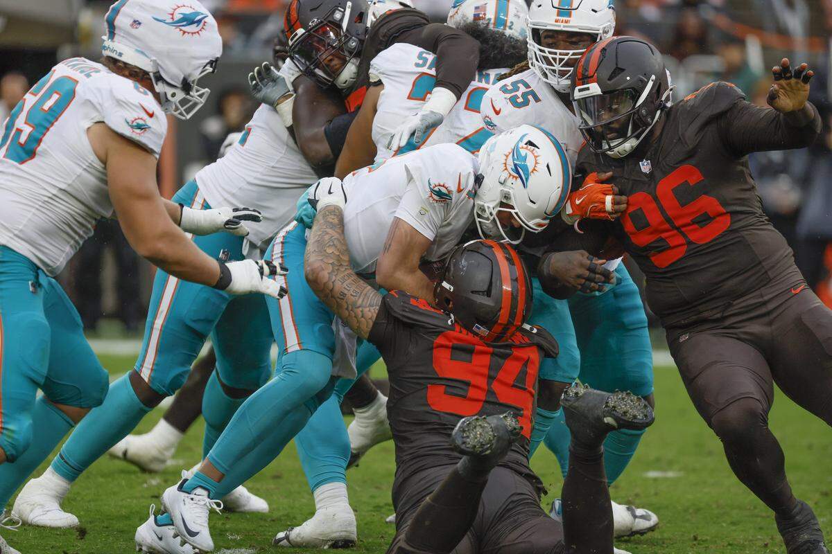 Miami Dolphins quarterback Quinn Ewers (14) is tackled by Cleveland Browns defensive tackle Mason Graham (94) after dropping the ball after a snap during the second half of an NFL football game at Huntington Bank Field in Cleveland, Ohio, on Sunday, October 19, 2025.