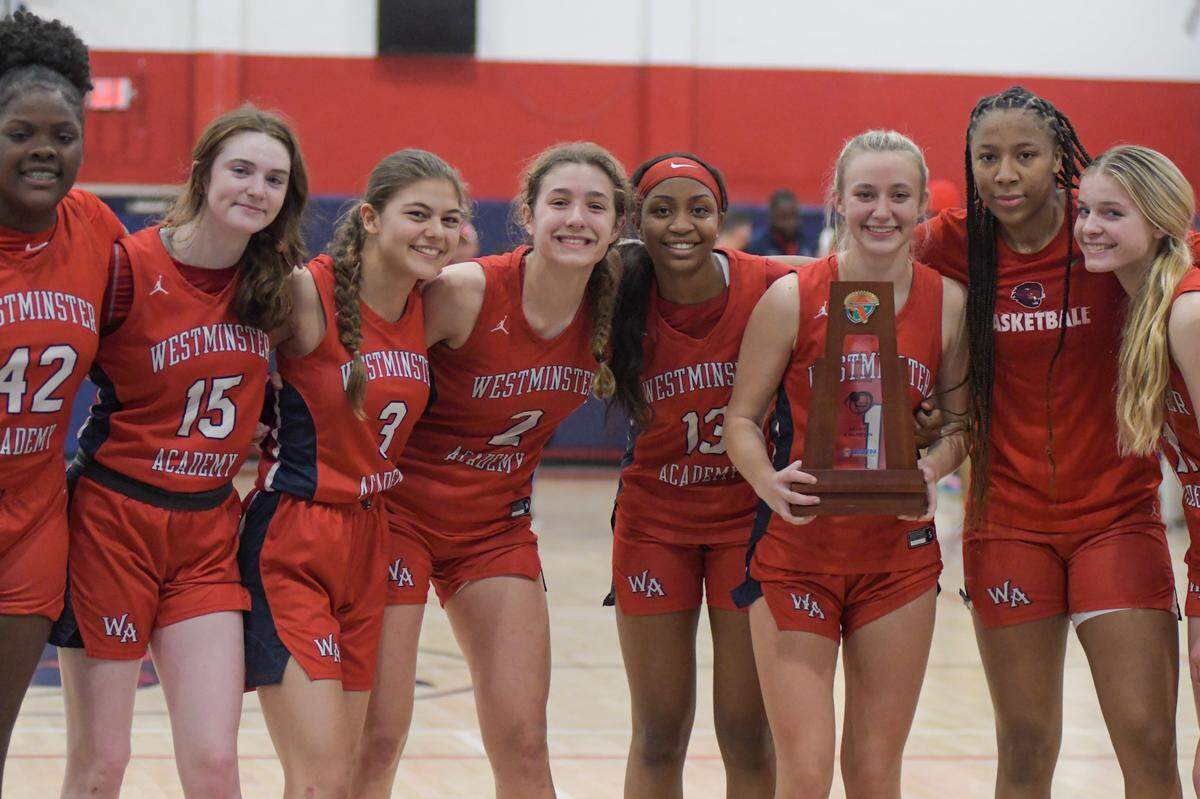 The Westminster Academy girls basketball team celebrates after being Miami Country Day for the Region 4-3A title on Friday, Feb. 18, 2022.