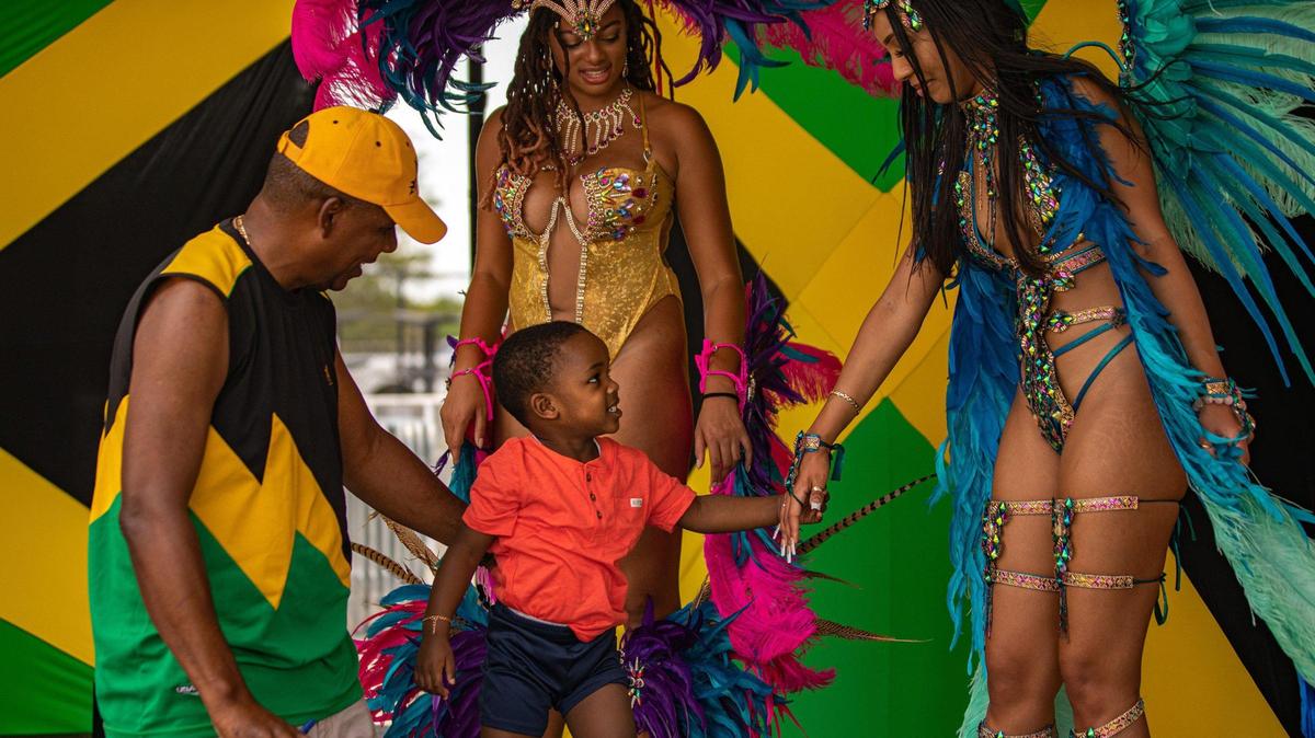 Marvin Wilmot (left) guides his grandson Leo Jackson, 3, in greeting Last Band Standing Miami performers Saria Belizaire (middle) and Skye Ramos during the Jamaica Emancipendence Ole Time Fair at Miramar Regional Park Amphitheater in Miramar, Florida on Saturday, August 6, 2022. The free family-friendly event included kids trampolines, farmers market and dancing in celebration of Jamaica’s 60th Independence Anniversary.