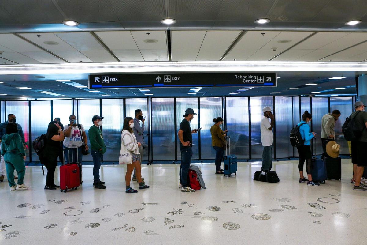 Travelers wait to board a flight at Miami International Airport in Miami, Florida, on Tuesday, November 23, 2021.