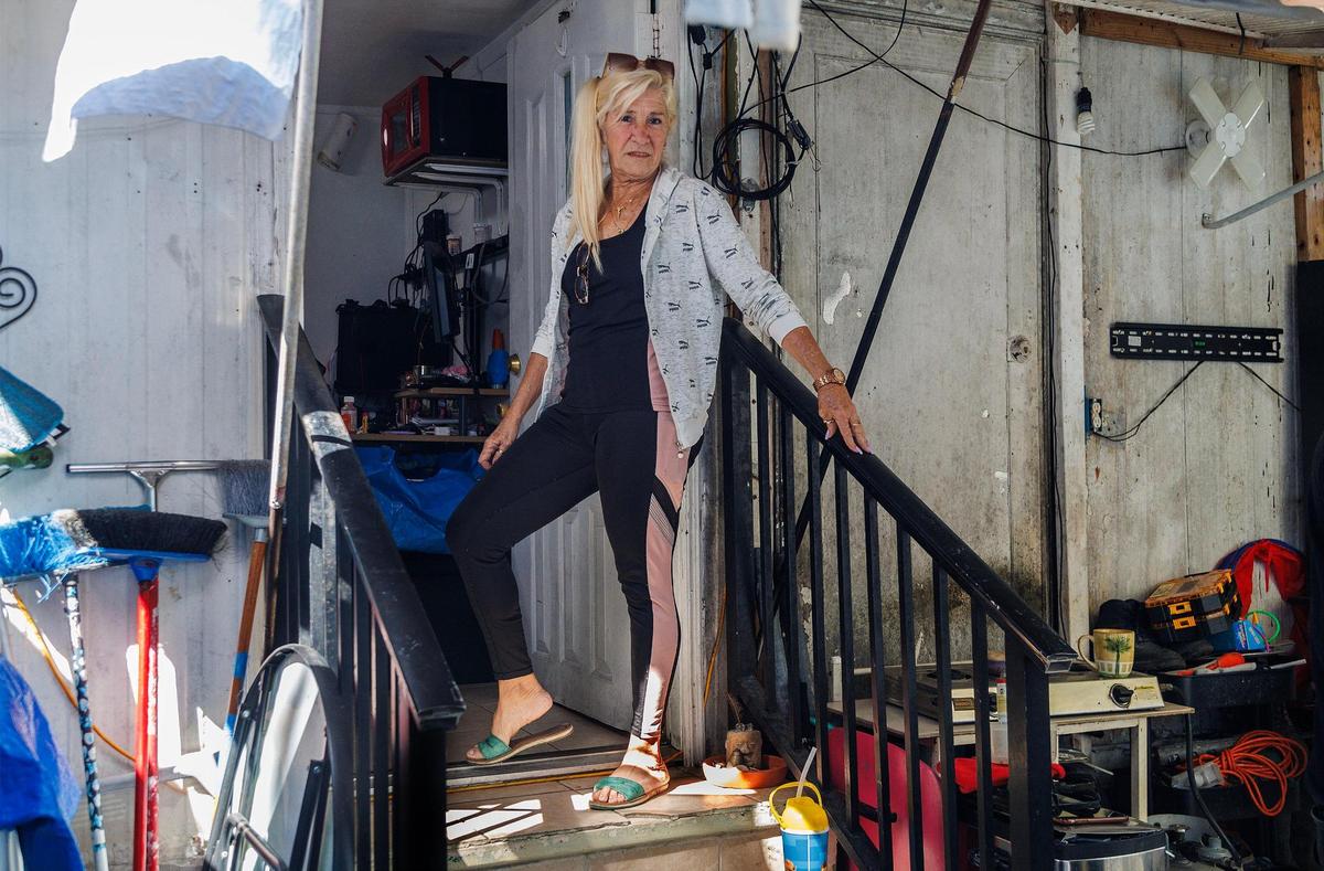 Amalia Olivares posa en las escaleras de la casa móvil de su amiga Gloria Pérez en el Gables Trailer Park, en Little Gables. El parque, que cuenta con aproximadamente 90 casas móviles, está situado frente a Graceland Memorial Park North, en SW 44th Avenue. A los habitante les preocupa ser desplazados ya que la ciudad de Coral Gables está avanzando con el proceso de anexión, el miércoles 18 de octubre de 2023.