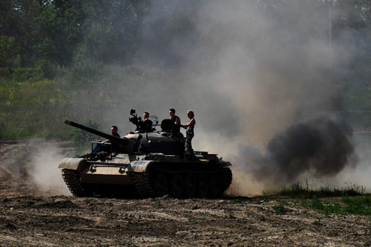 Varias personas montan sobre un tanque soviético T-54 mientras visitan el Parque Histórico de Tanques en San Petersburgo, el 15 de julio de 2023. Las fuerzas armadas de Cuba utilizan tanques T-54.
