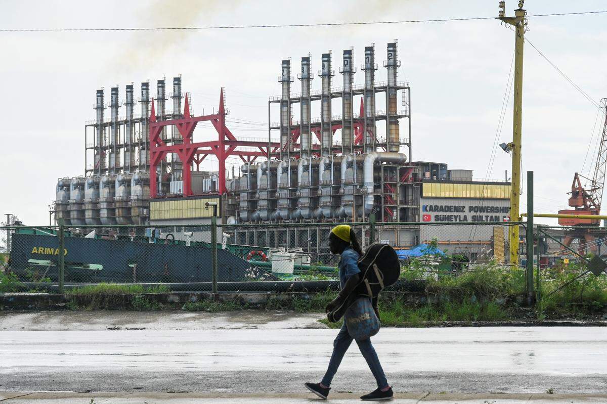 Un cubano camina junto a una central eléctrica flotante en el puerto de La Habana el 21 de octubre de 2024. (Foto de YAMIL LAGE/AFP) (Foto de YAMIL LAGE/AFP vía Getty Images)