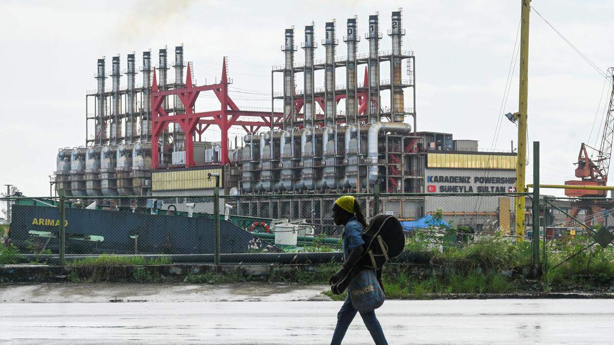 A Cuban walks next to a floating power plant in Havana Harbor on October 21, 2024. (Photo by YAMIL LAGE / AFP) (Photo by YAMIL LAGE/AFP via Getty Images)