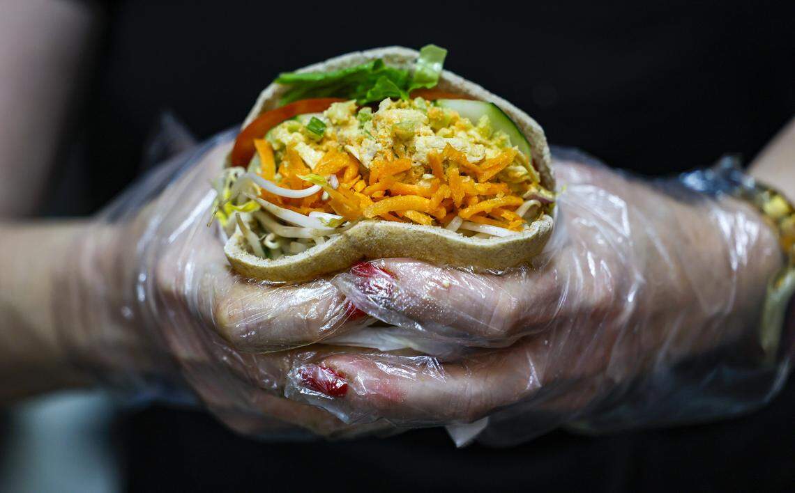 Erin Compton, the owner of The Last Carrot, holds a veggie pita wrap at the restaurant.