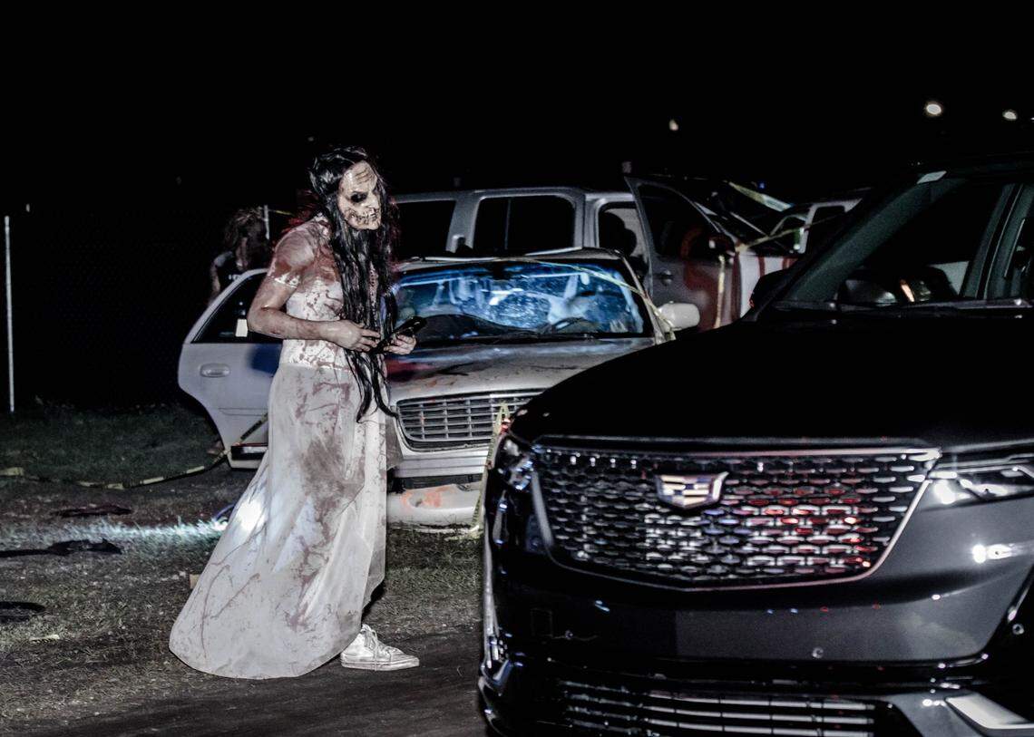 Creepy zombies walk up to your car at The Horrorland. Lock the doors.