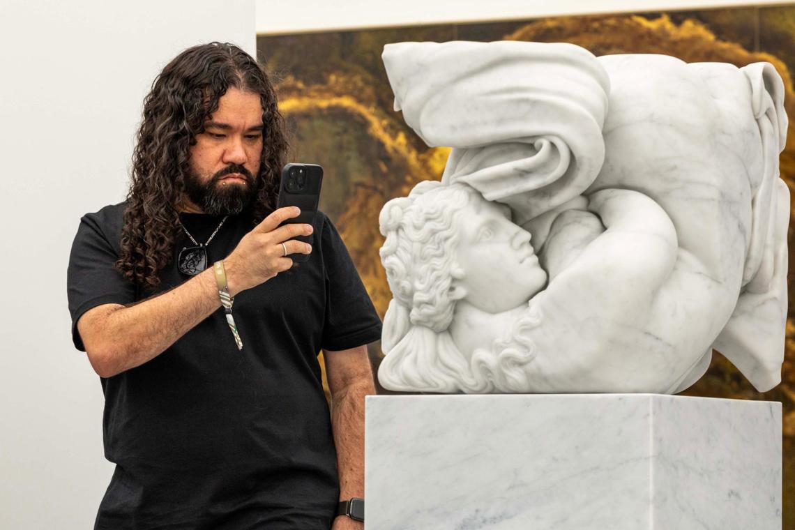 At UNTITLED on Tuesday in Miami Beach, Che Morales takes a photo of Adam Parker Smith’s ‘Venus’ while visiting during Miami Art Week for the 15th time.