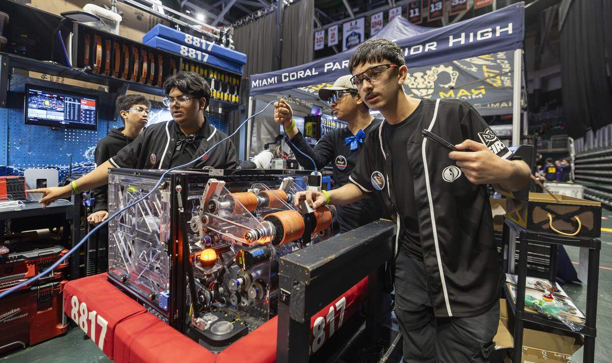 South Dade Senior High School student Christian Diaz, 16, right, a member of Buccaneer Robotics, troubleshoots his team’s robot, Placidusax, as they prepare to compete in the 2026 FIRST Robotics South Florida Regional Competition at the University of Miami’s Watsco Center on Friday, April 10, 2026, in Coral Gables, Fla. Participants from local school districts, surrounding states, and international teams are competing for an opportunity to earn a spot at the 2026 FIRST World Championship.