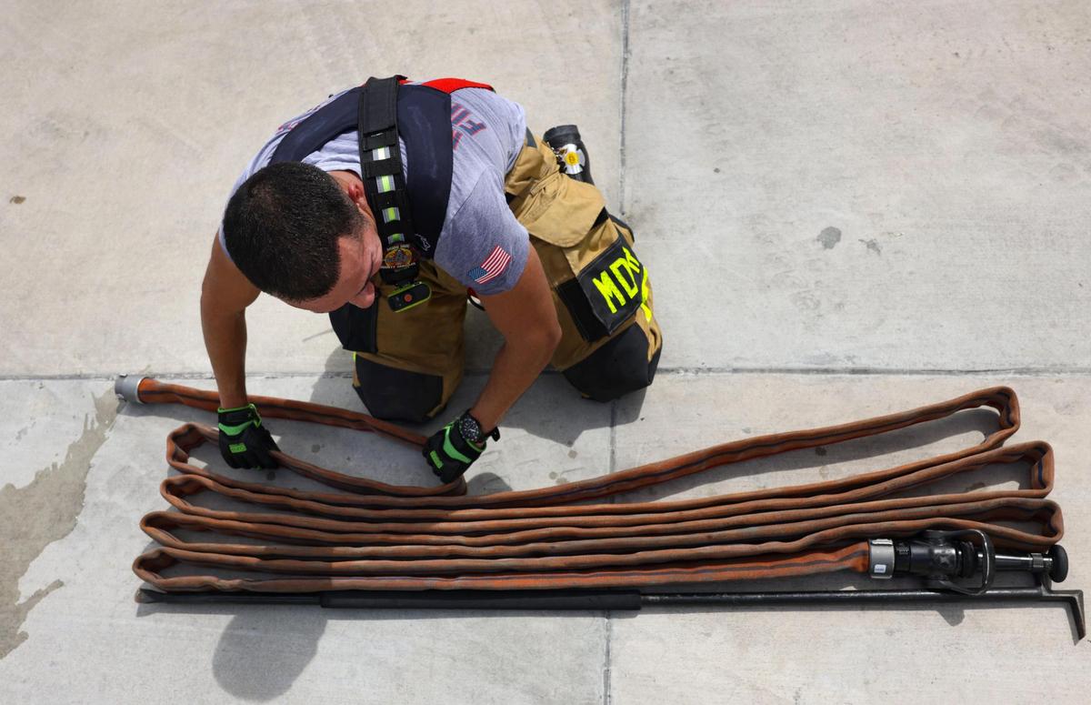 Jared Lago, a new crew member, folds up the fire hose after a training exercise during a shift on Thursday, April 3, 2025, at Dolphin Station 68 in Sweetwater, Florida. Public safety expenses like the fire department are a top recipient of property taxes in Miami-Dade.