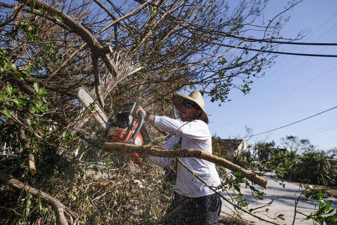Brad Morris with Monroe County Fire Rescue trims a fallen tree from a neighborhood in Cudjoe Key. The island community took a direct hit.