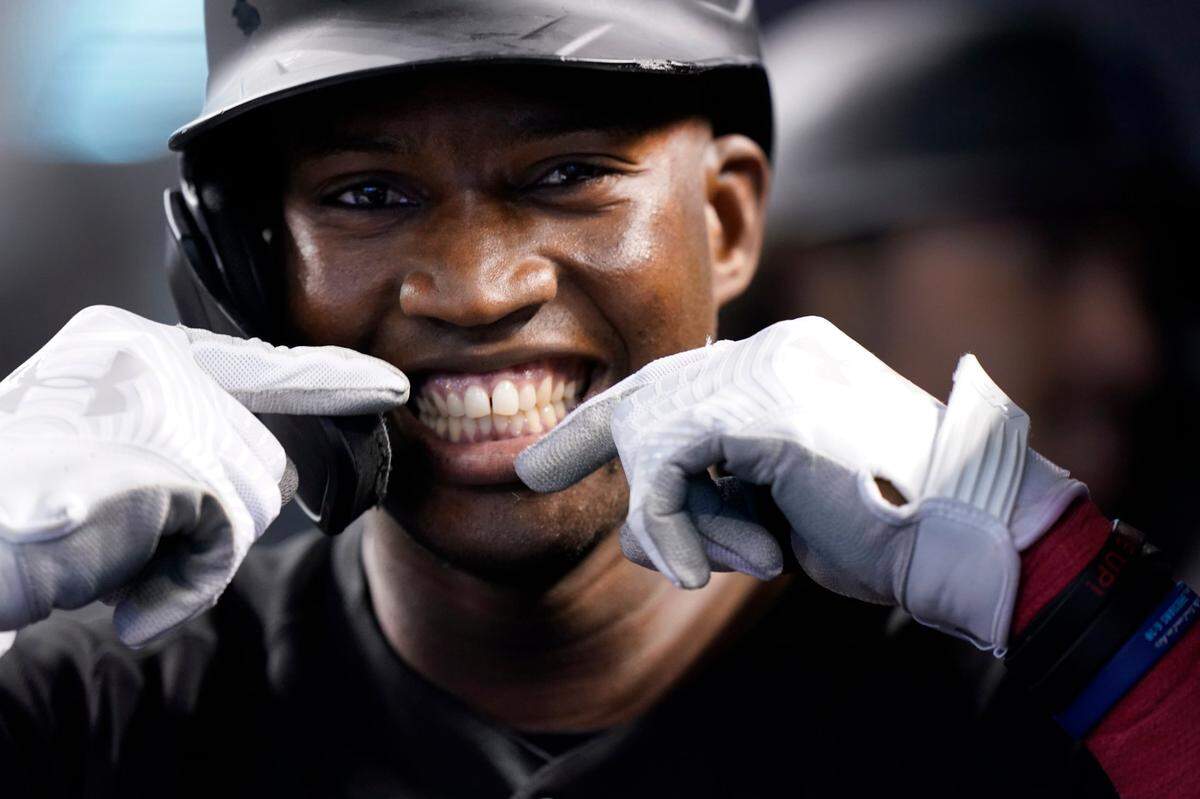 Miami Marlins’ Jesus Sanchez smiles for the cameras after he hit a home run, also scoring Jorge Alfaro and Brian Anderson, during the first inning of a baseball game against the Cincinnati Reds, Saturday, Aug. 28, 2021, in Miami. (AP Photo/Wilfredo Lee)