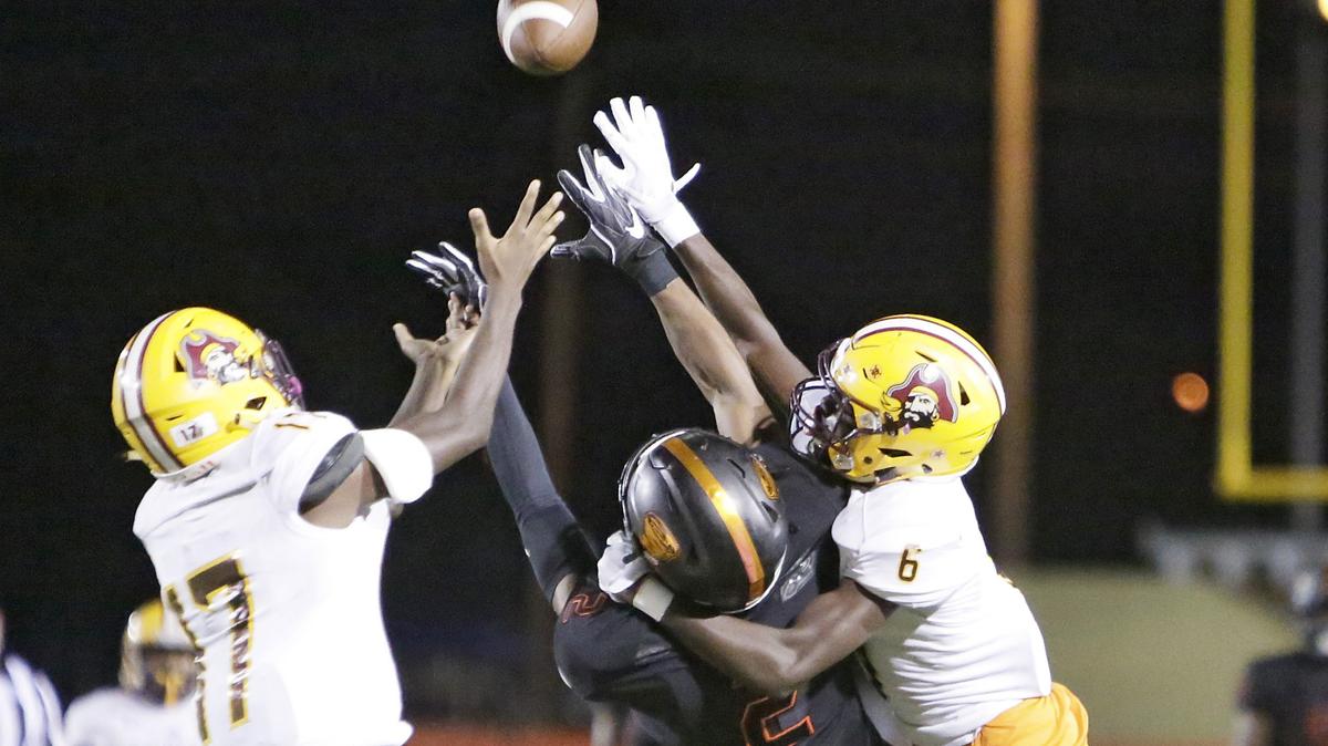 Booker T. Washington Tornadoes’ wide receiver Theodore Richardson (2) and Glades Central Raiders’ defensive backs Earnest Jackson (17) and Antonio Laidler go airborn while fighting for the pass during the Region 4-4A semifinal football game on Thursday, Nov. 14, 2018 at Traz Powell Stadium in Miami