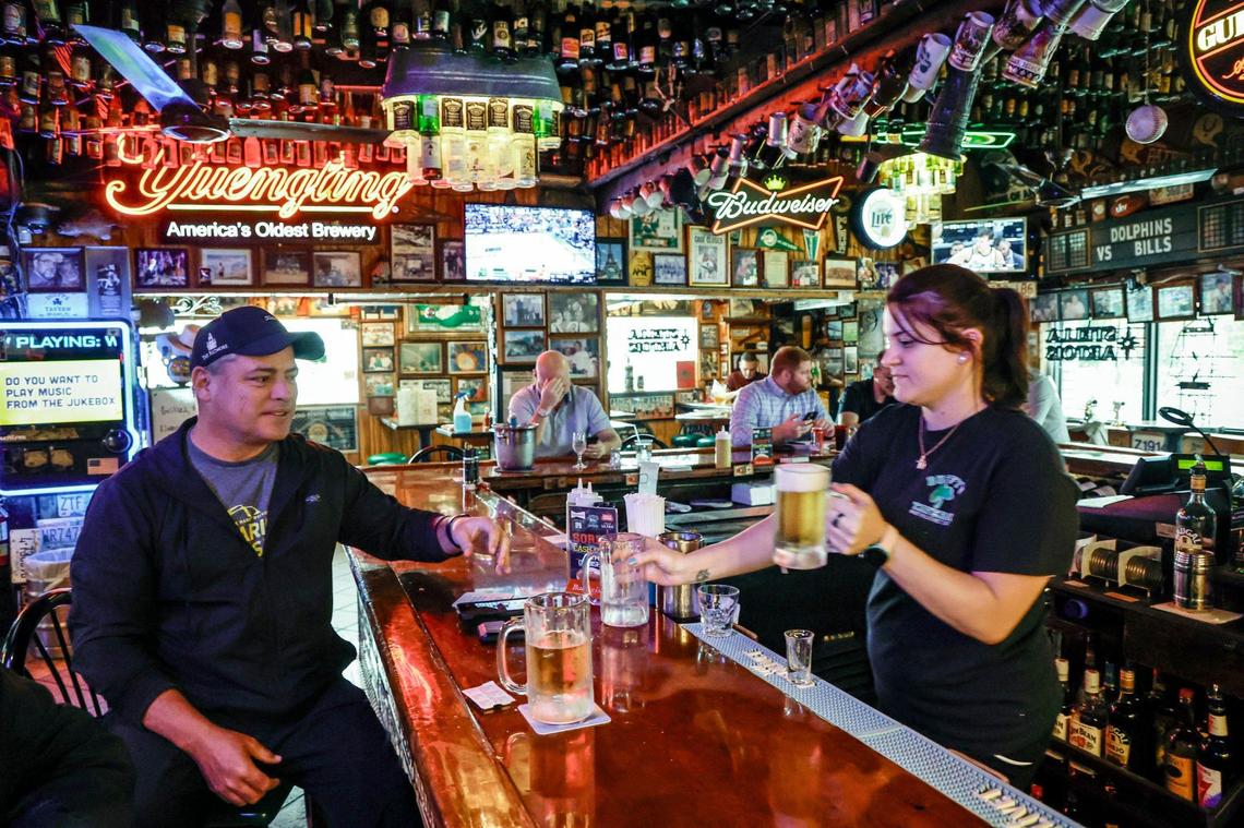 Gina Santibanez serves a mug of beer to Coral Gables resident Paul Hehir at Duffy’s Tavern in Miami.