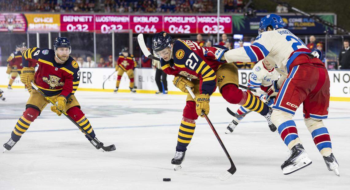Florida Panthers center Eetu Luostarinen (27) and New York Rangers defenseman Matthew Robertson (29) compete for the puck in the third period of their Winter Classic outdoor hockey game at loanDepot park on Friday, Jan. 2, 2026, in Miami, Fla.