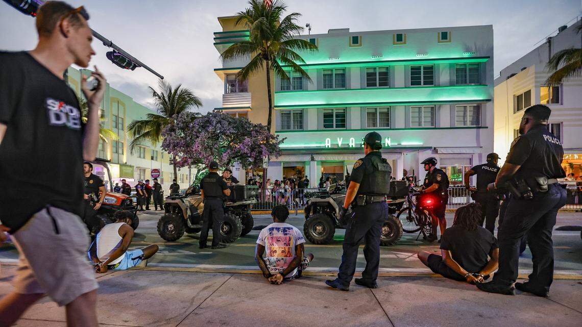 Miami Beach police officers detain three men on Ocean Drive across from the Avalon Hotel during spring break in Miami Beach on Saturday, March 16, 2024.