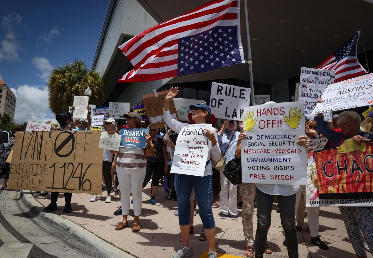 People gather outside of the Social Security Administration building during a May Day rally themed “Protect Social Security, Protect Workers” on Thursday, May 1, 2025, in Miami. A woman who preferred to stay anonymous said, “I didn’t just come to protect my Social Security, but everyone else’s, too.”